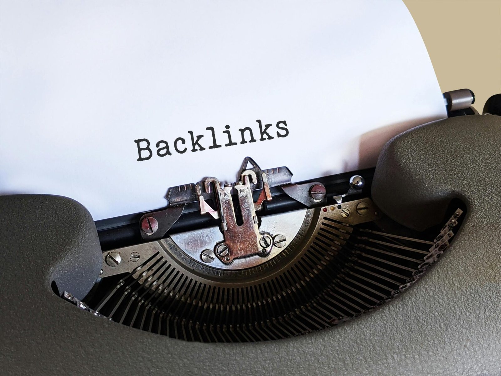 Close-up of a vintage typewriter printing the word 'Backlinks,' emphasizing content and SEO concepts.